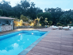 Terrasse en lames de bois naturel entourant une piscine moderne. Lames de terrasse en bois naturel autour d’une piscine moderne